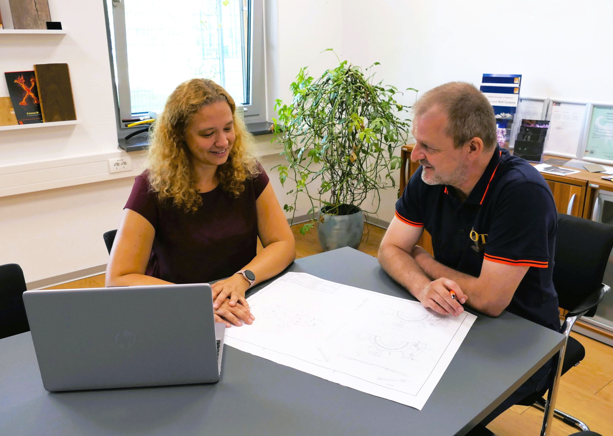 Mann und Frau sitzen am Schreibtisch im Gespräch bei der Arbeit