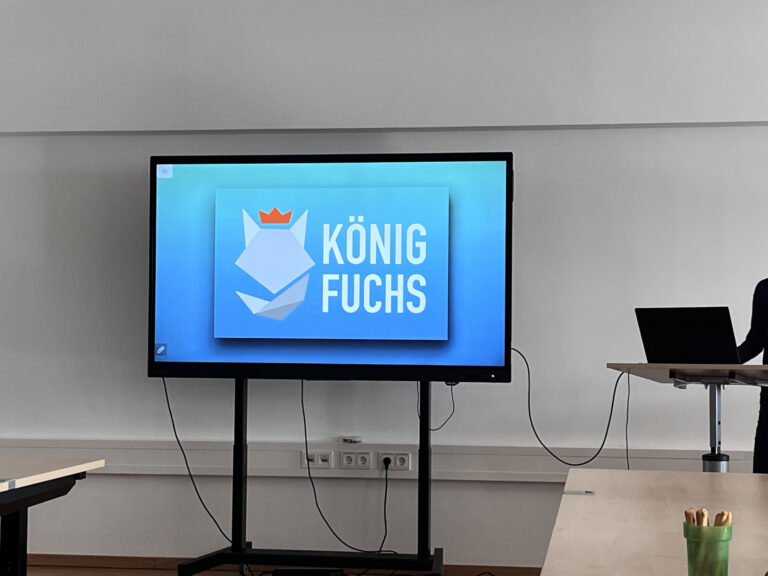 Startfolie der Präsentation der König Fuchs Lernagentur mit dem Logo: stilisierter Kopf eines Fuchses mit Krone und Schriftzug "König Fuchs"