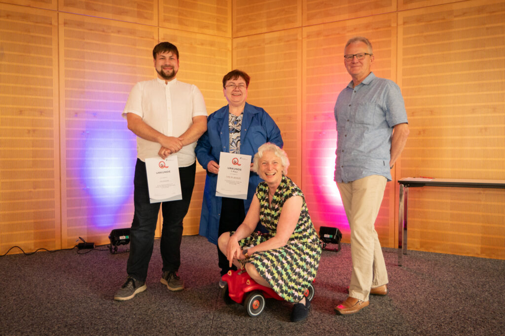 Die Slammerinnen und Slamer am 1. Q-Slam des DGQ-Regionalkreis Leipzig posieren mit Urkunden für das Abschlussfoto.