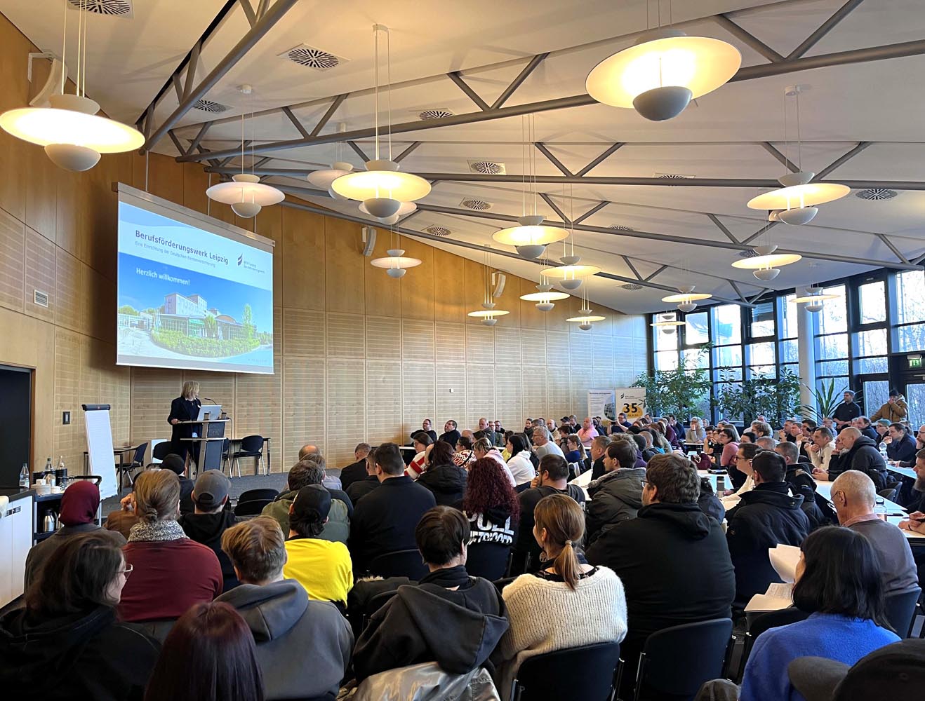 Die Geschäftsführerin begrüßt die neuen Teilnehmenden in der Aula.