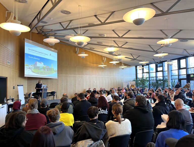 Die Geschäftsführerin begrüßt die neuen Teilnehmenden in der Aula.