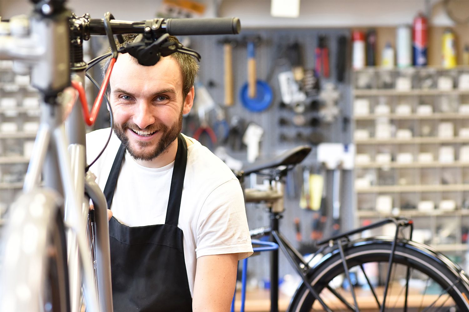 Zweiradmechatroniker mit Schürze in einer Fahrradwerkstatt